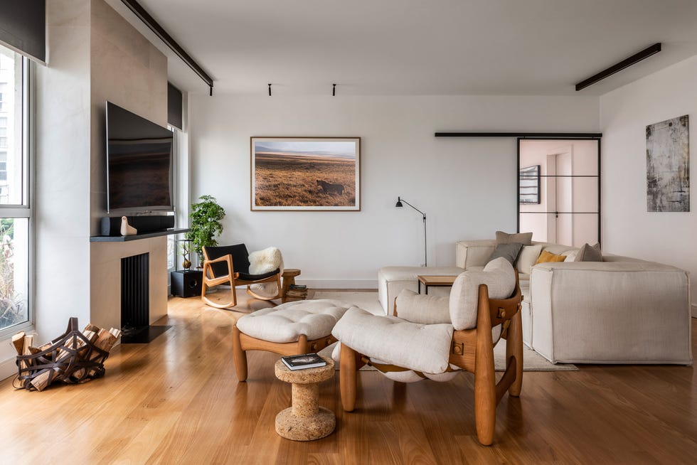 salón de diseño moderno con sofá con chaise longue beige y butaca con reposapiés de madera con cojines beige
