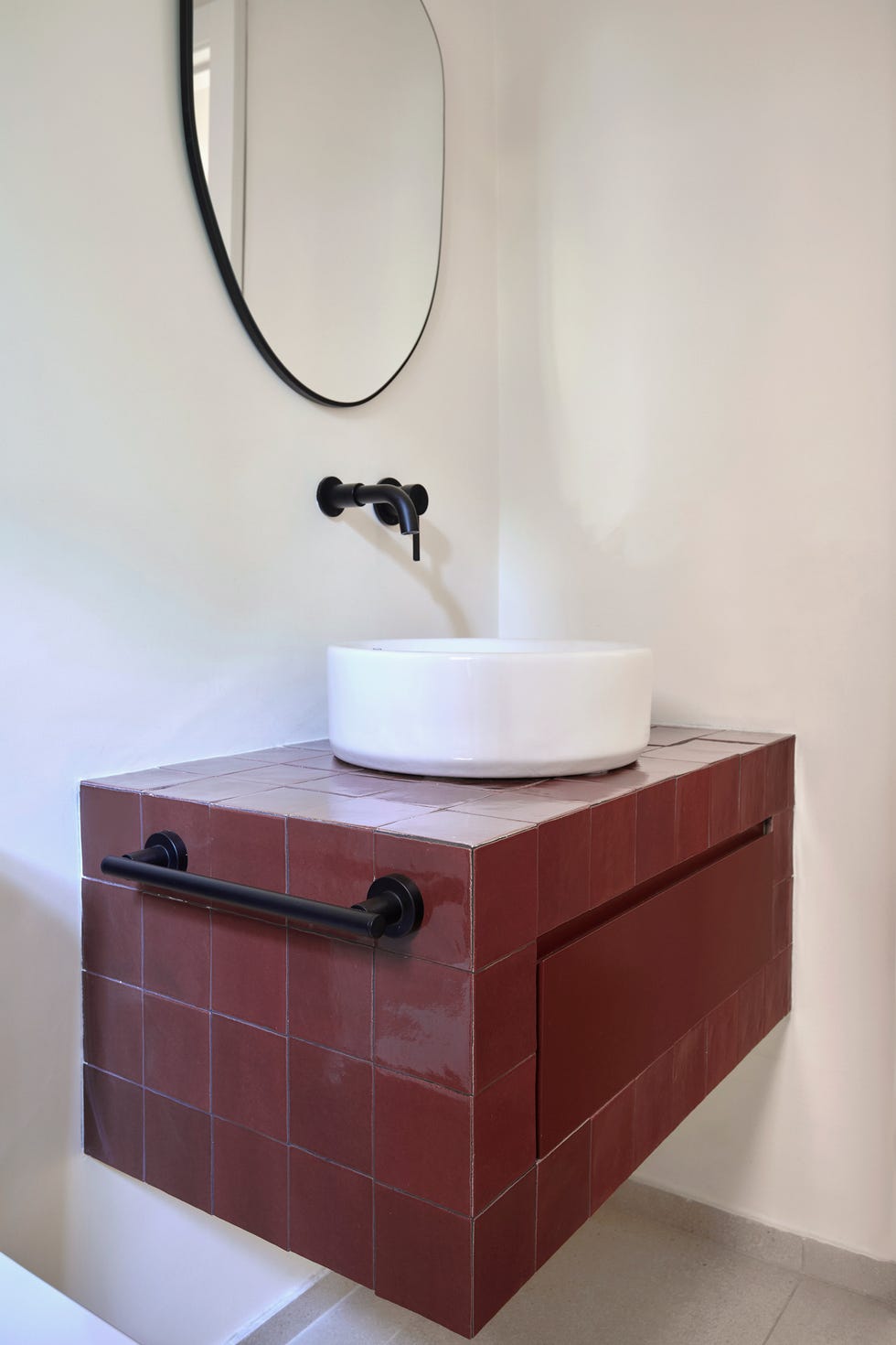 aseo con mueble volado con azulejos granates