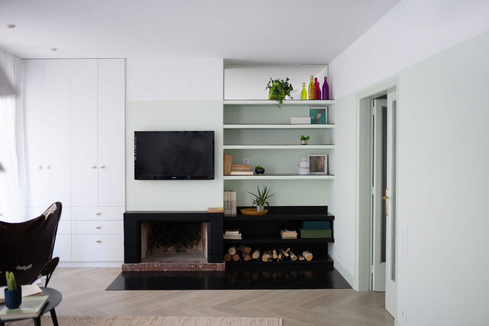 salón con chimenea y pared pintada en verde empolvado