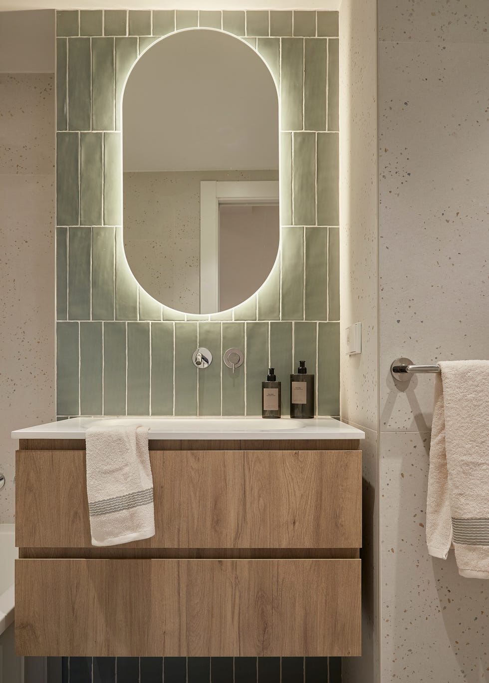 baño con mueble de madera volado y azulejos verdes