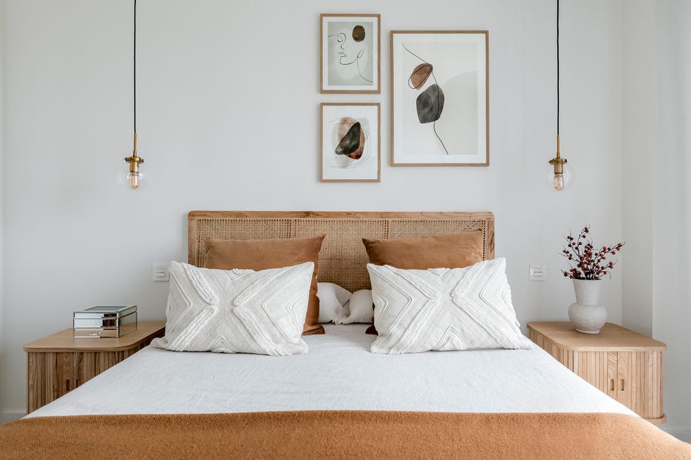 cama con cabecero de rejilla y mesitas de madera con lámparas suspendidas