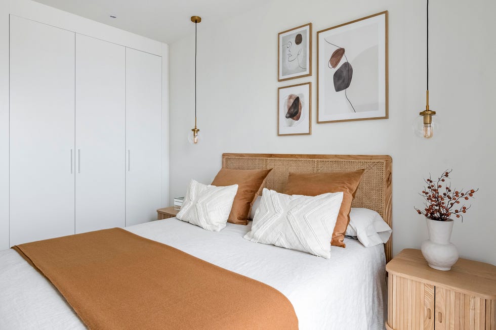 cama con cabecero de rejilla y mesitas de madera con lámparas suspendidas