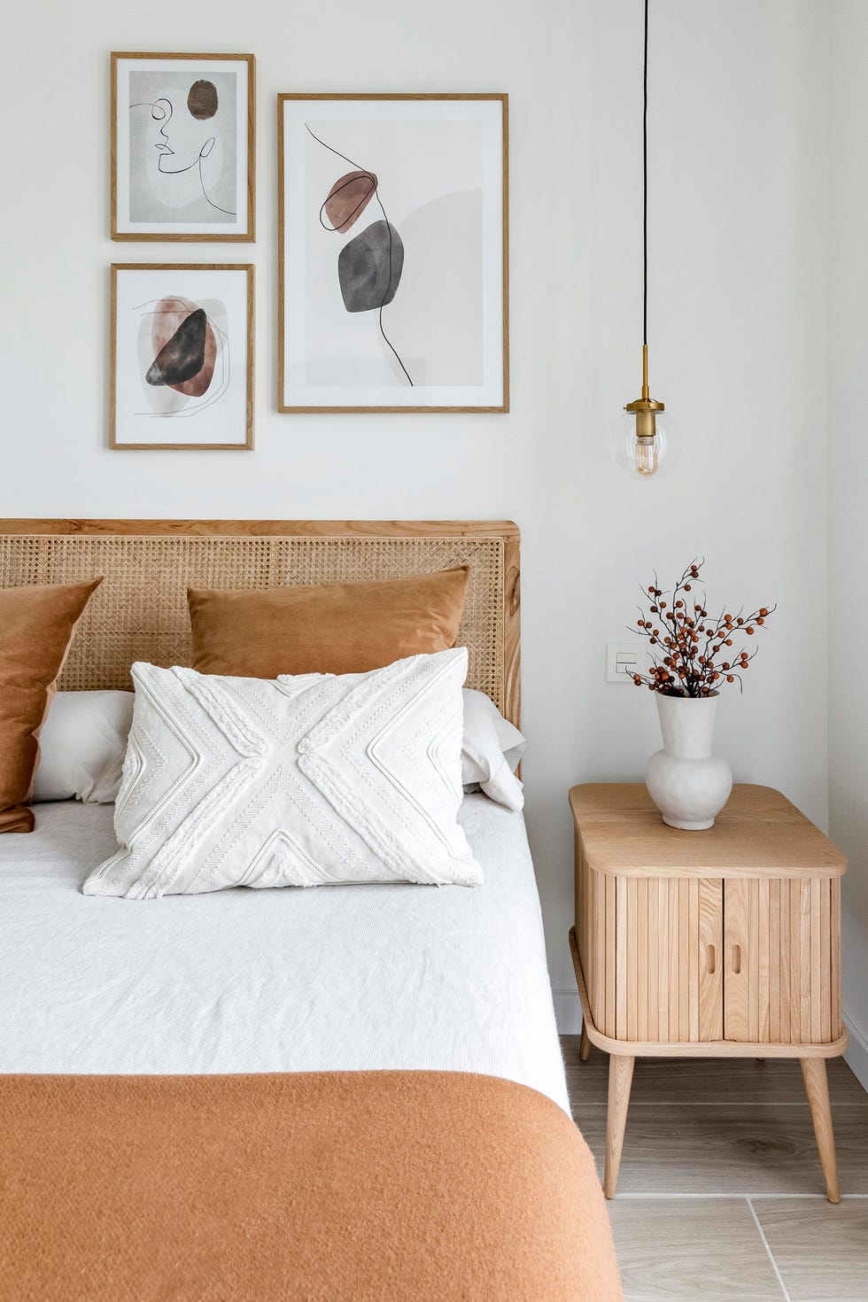 cama con cabecero de rejilla y mesitas de madera con lámparas suspendidas