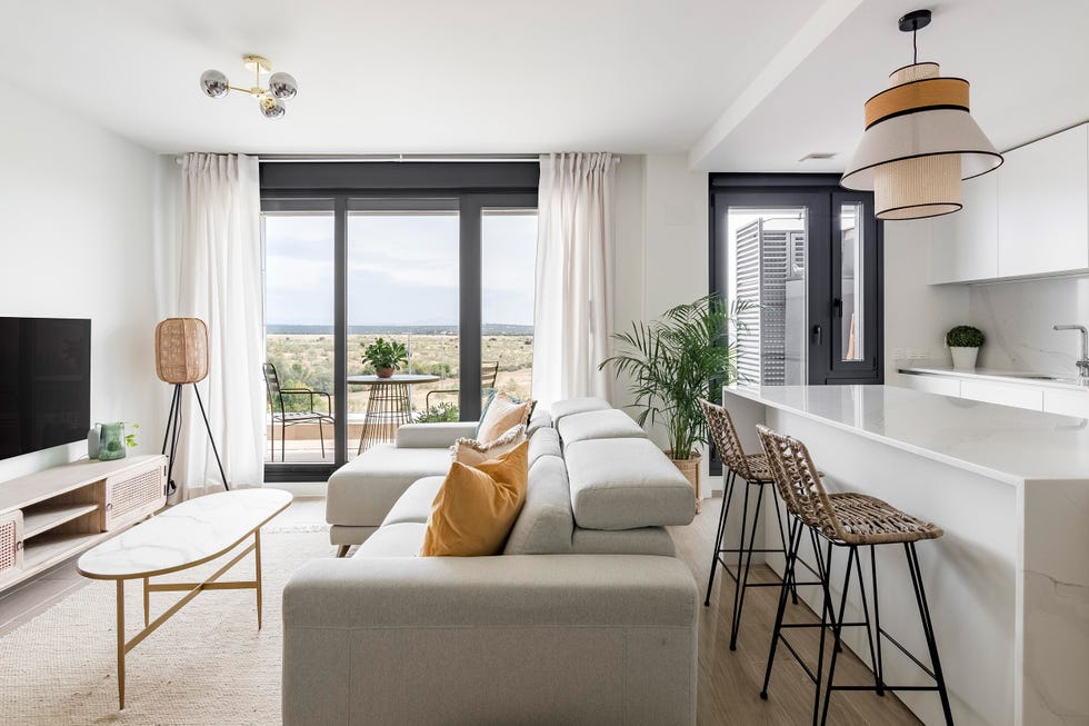 cocina con isla integrada en el salón de diseño nórdico con vistas a la terraza