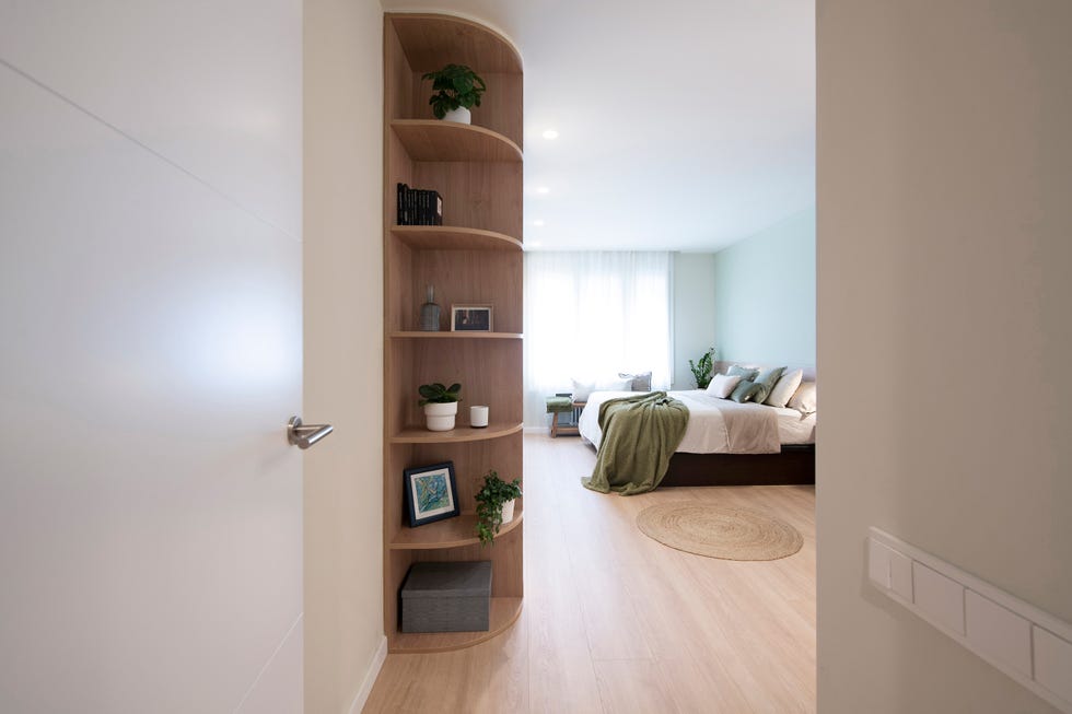 dormitorio con estantería de madera y pared verde