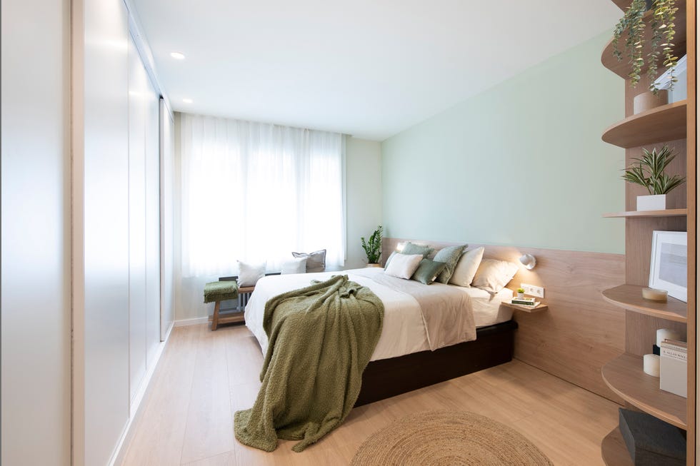 dormitorio con cabecero de madera y pared verde