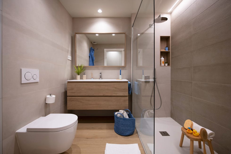 baño con ducha y mueble volado de madera