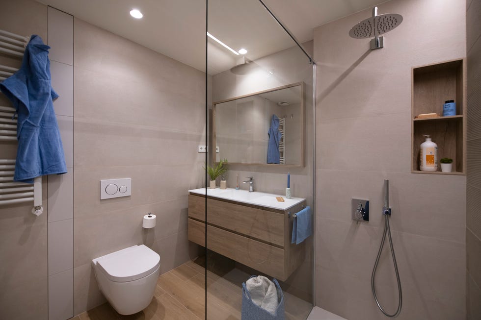 baño con ducha y mueble volado de madera