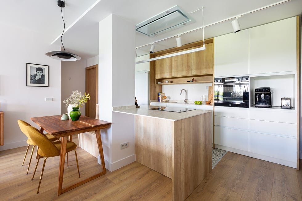 cocina con isla y mesa de comedor de madera con sillas mostaza