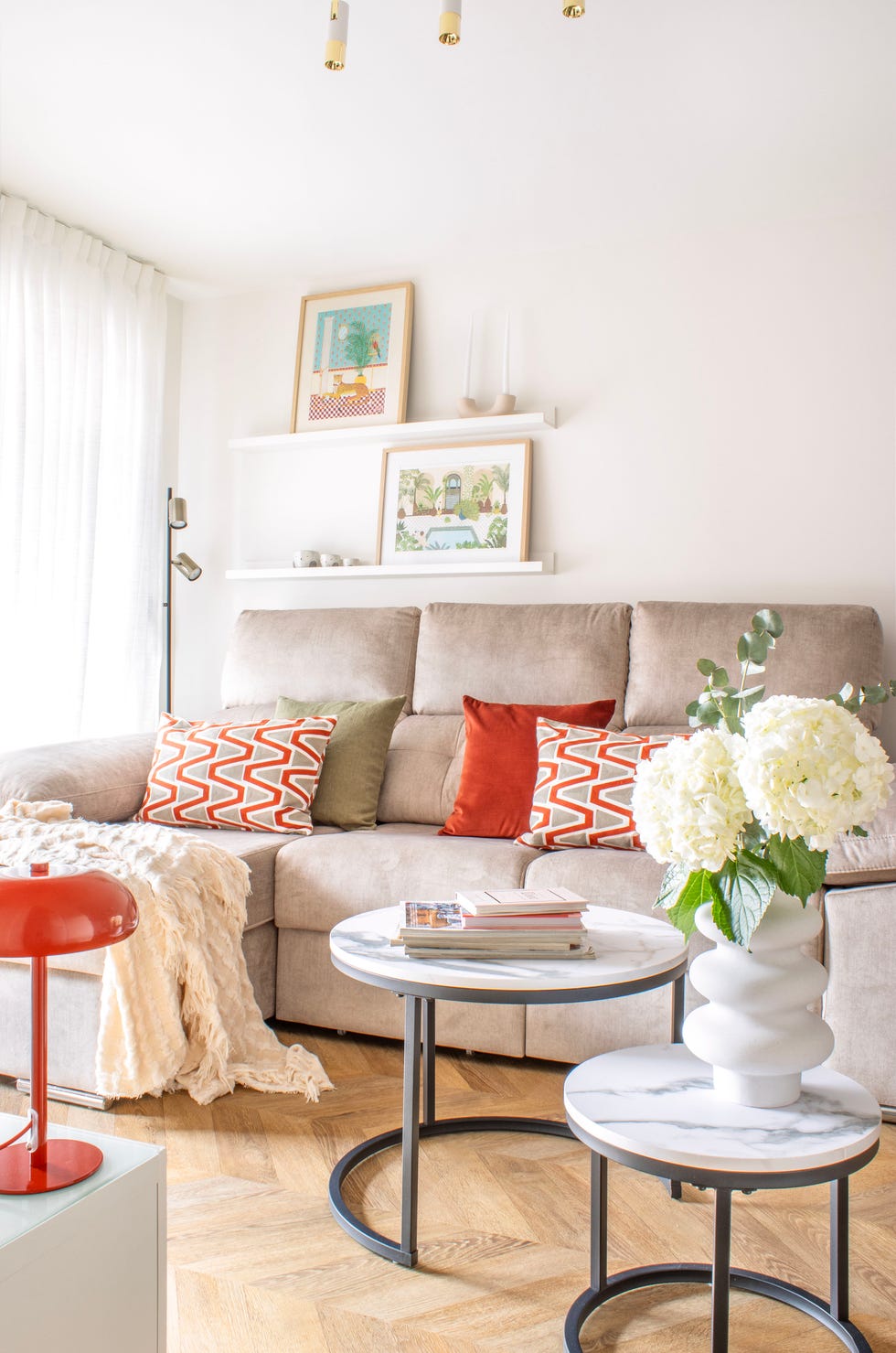 salón con sofá beige y mesas redondas de centro