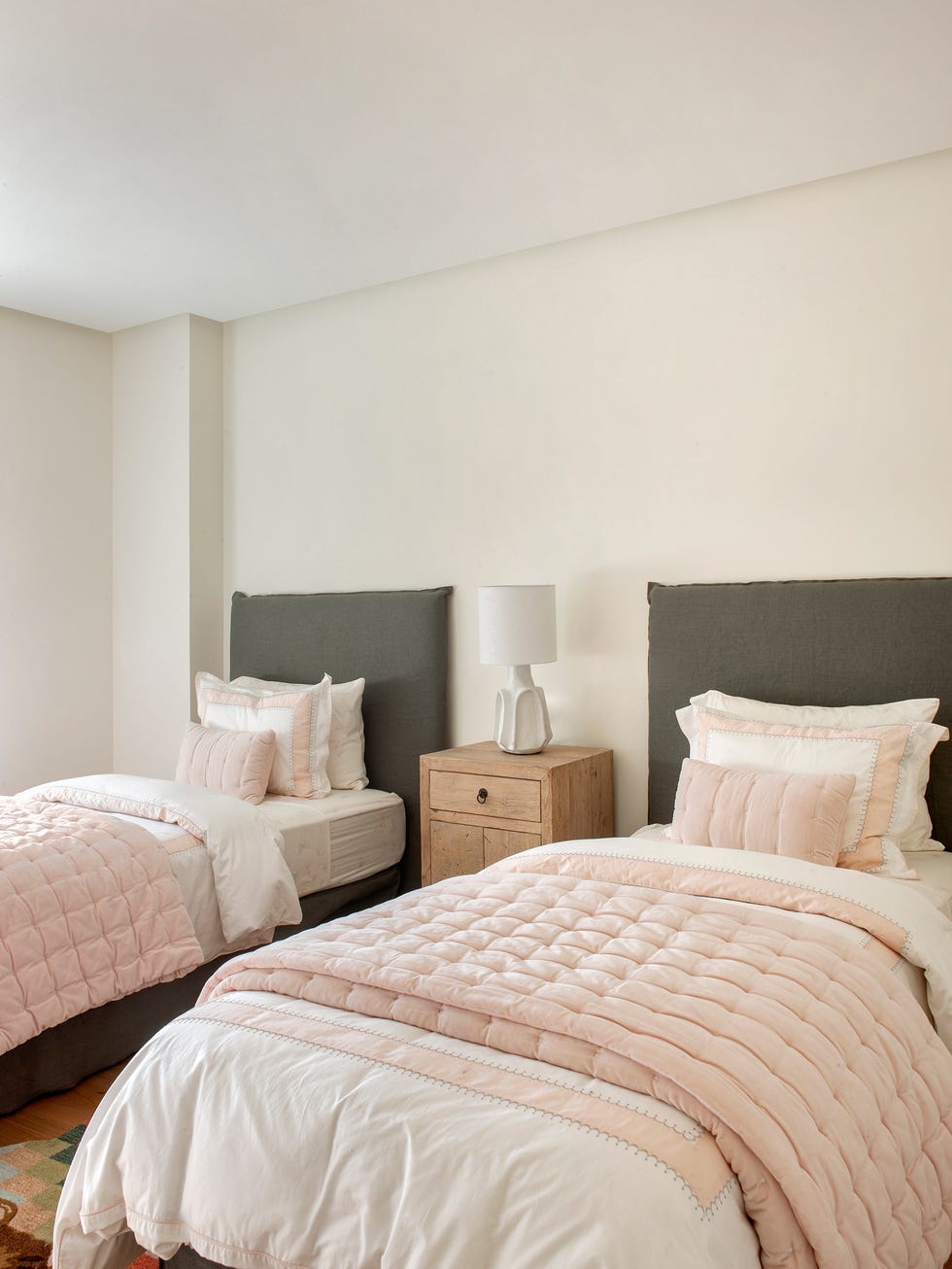 dormitorio con dos camas y una mesita de madera