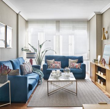 salón con sofás azules y mueble de tv de madera