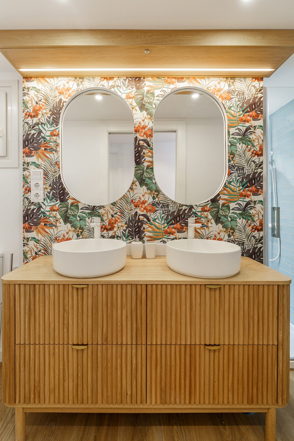 mueble de lavabo de palillería de madera y papel pintado con motivos exóticos