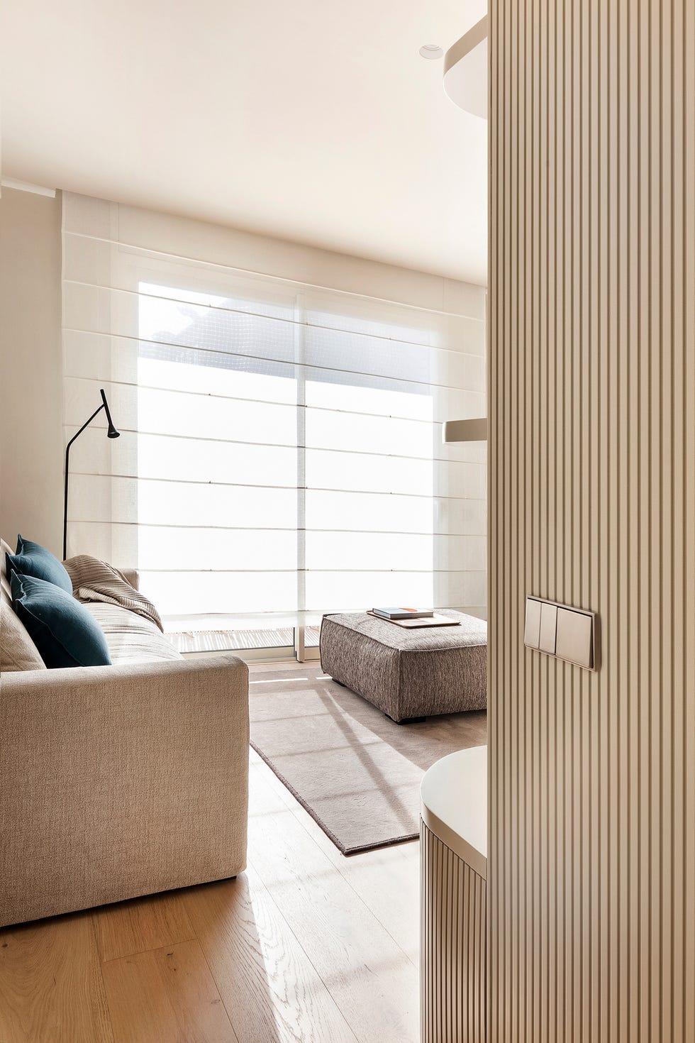 estantería blanca con diseño listonado y sofá beige