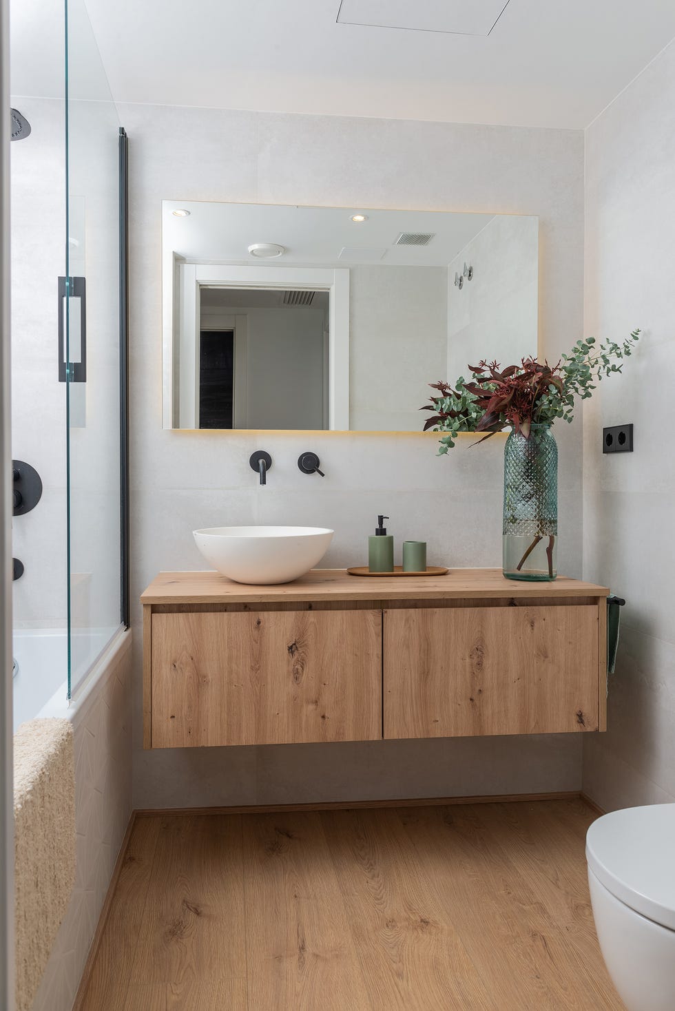 baño con mueble de madera volado y espejo rectangular