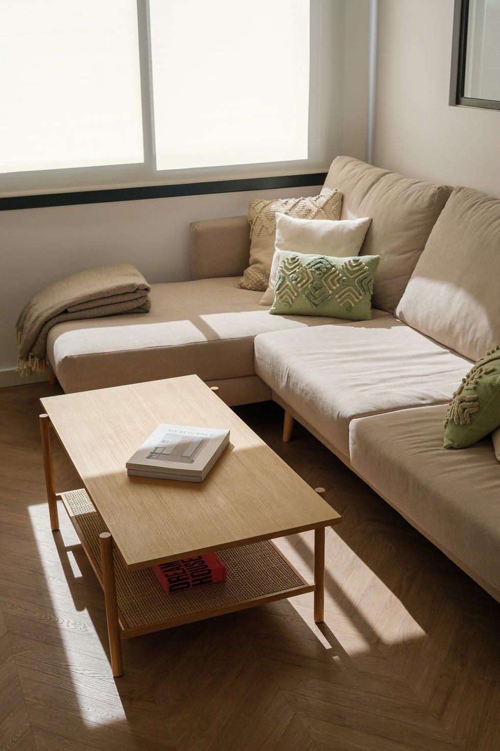 sofá beige con chaiselongue y mesa de centro de madera