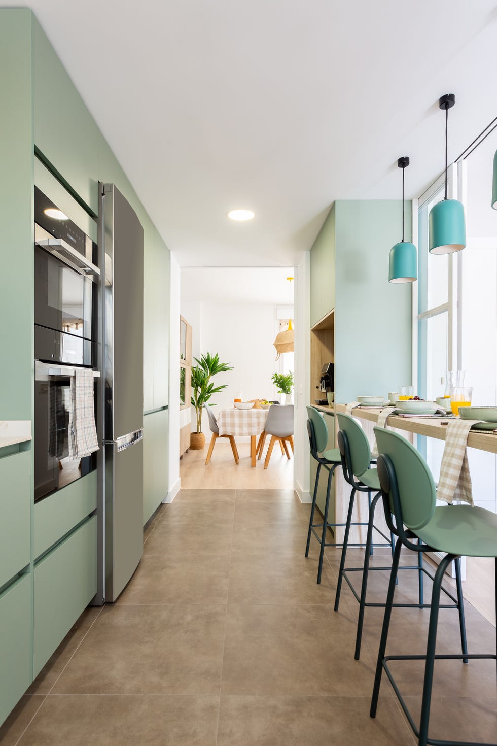 cocina de color verde con barra de desayunos