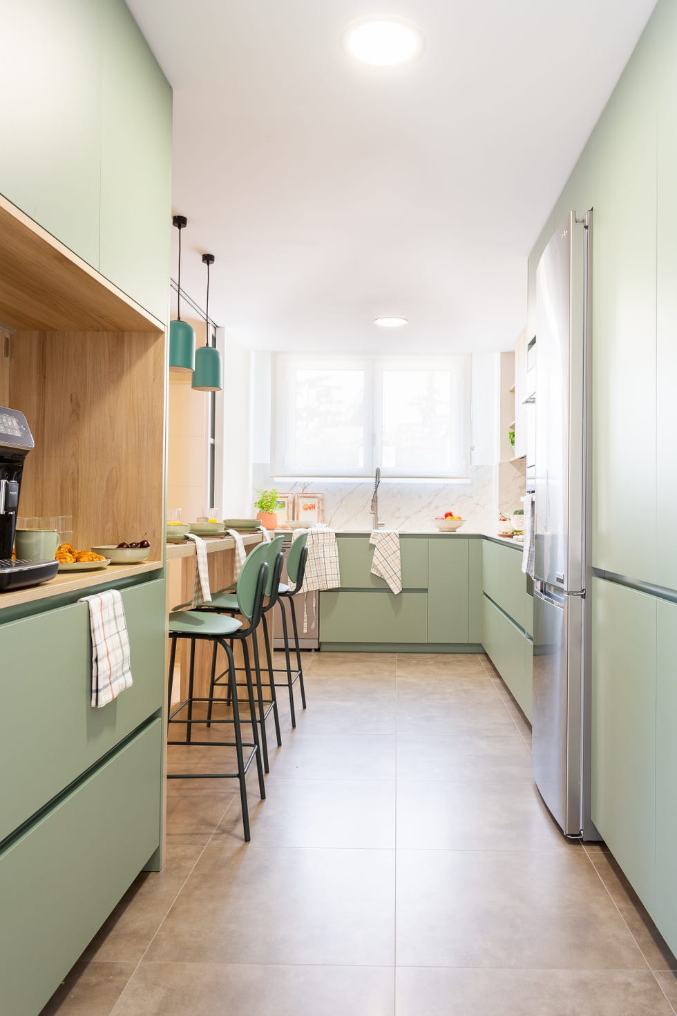 cocina de color verde con barra de desayunos