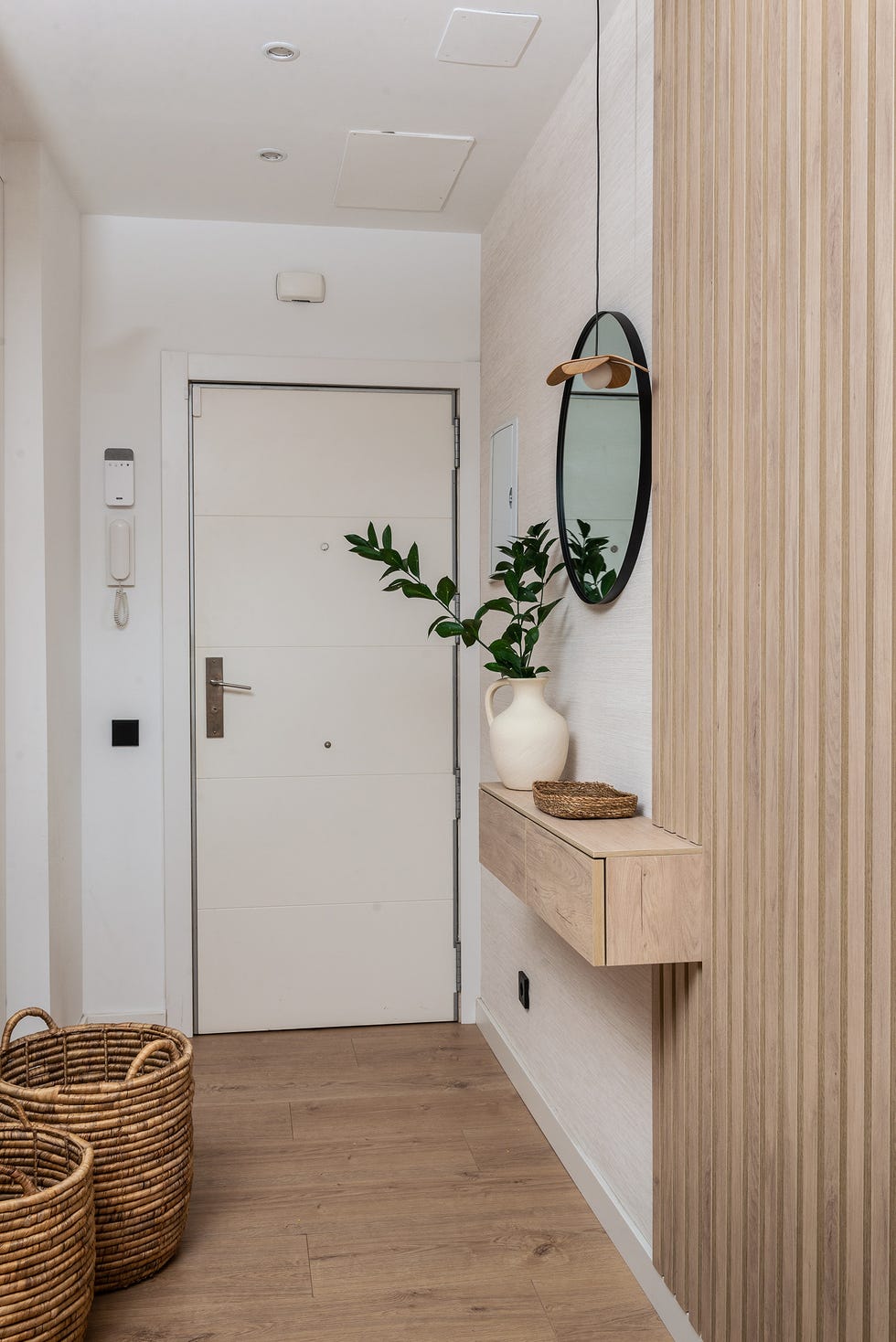 recibidor con consola de madera volada y pared listonada