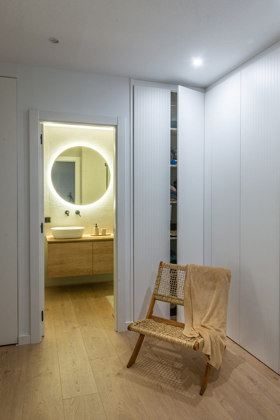 butaca de ratán junto a baño en suite