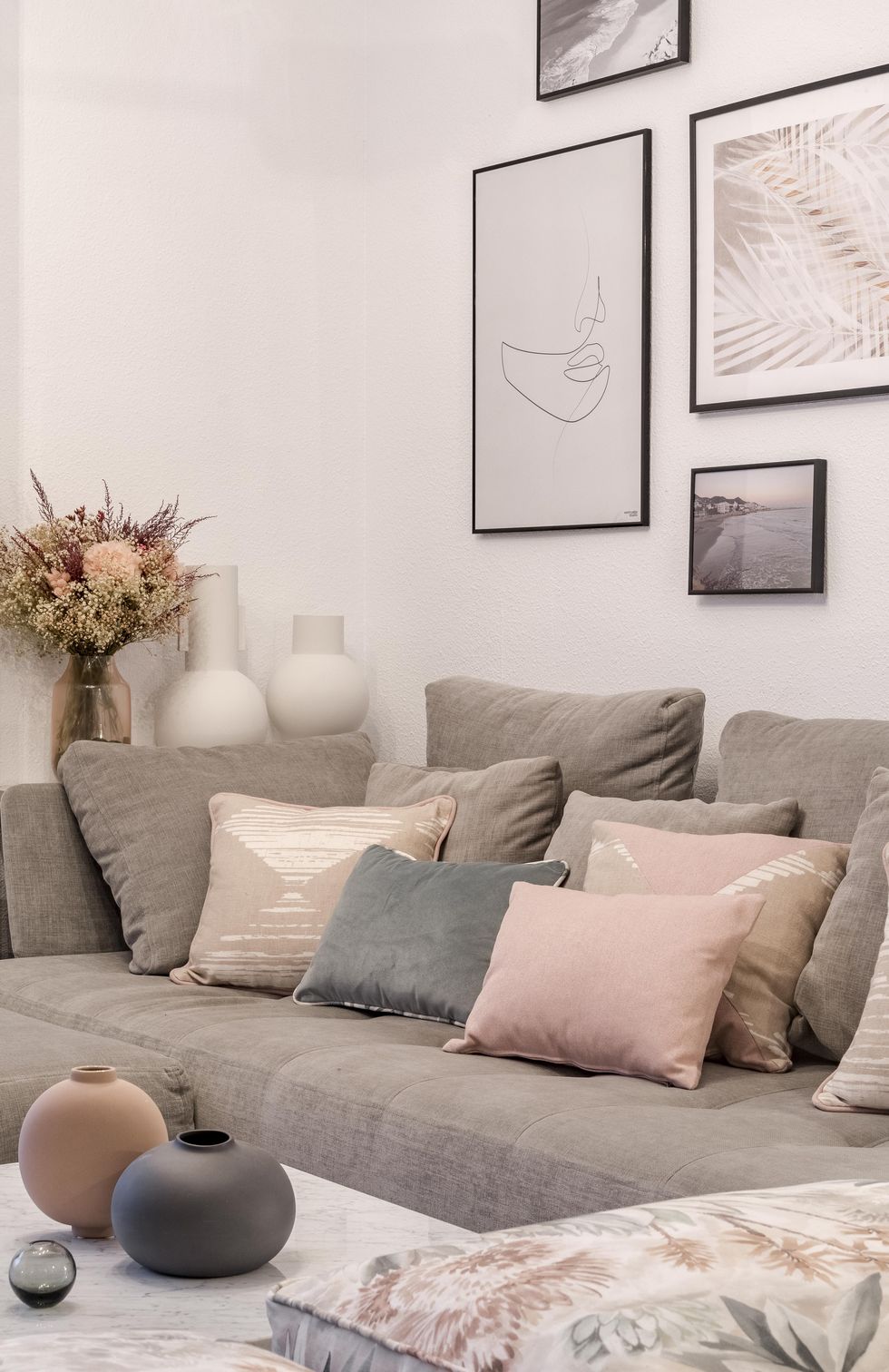 salón de estilo nórdico y boho con sofá gris con chaise longue y cojines en colores pastel