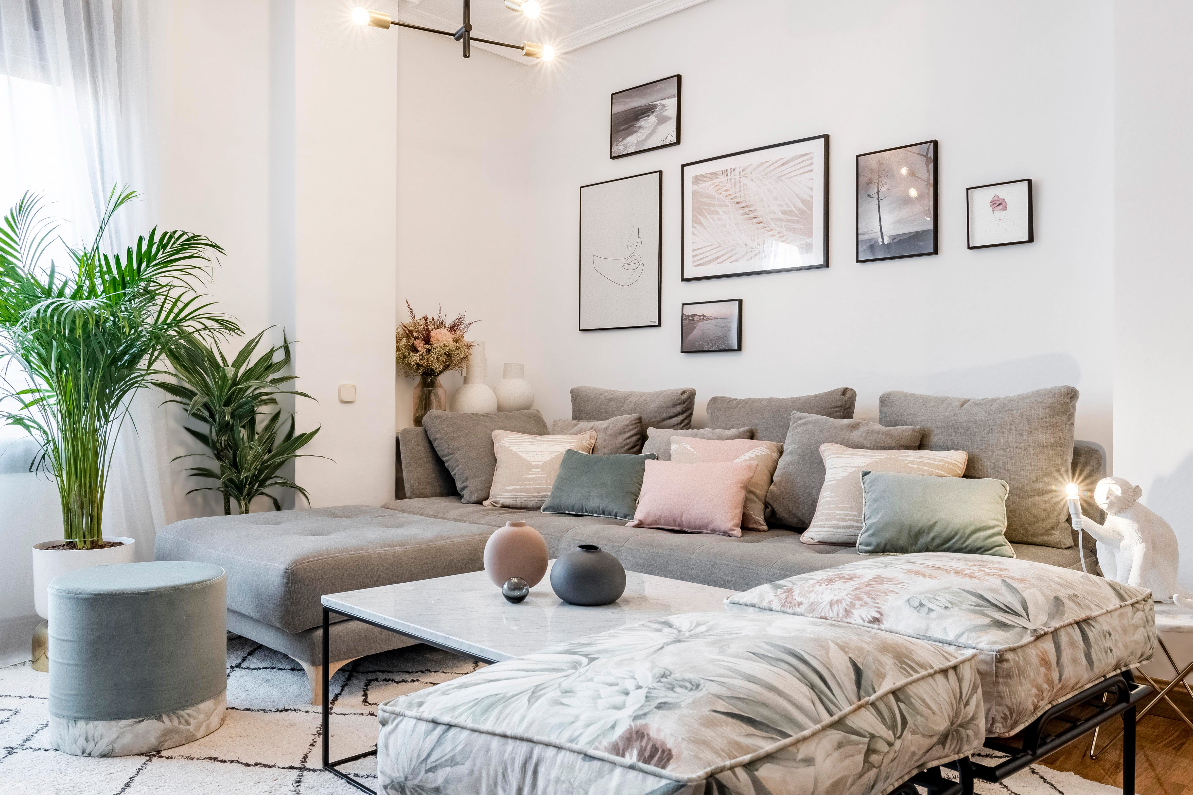 salón de estilo nórdico y boho con sofá gris con chaise longue y cojines en colores pastel