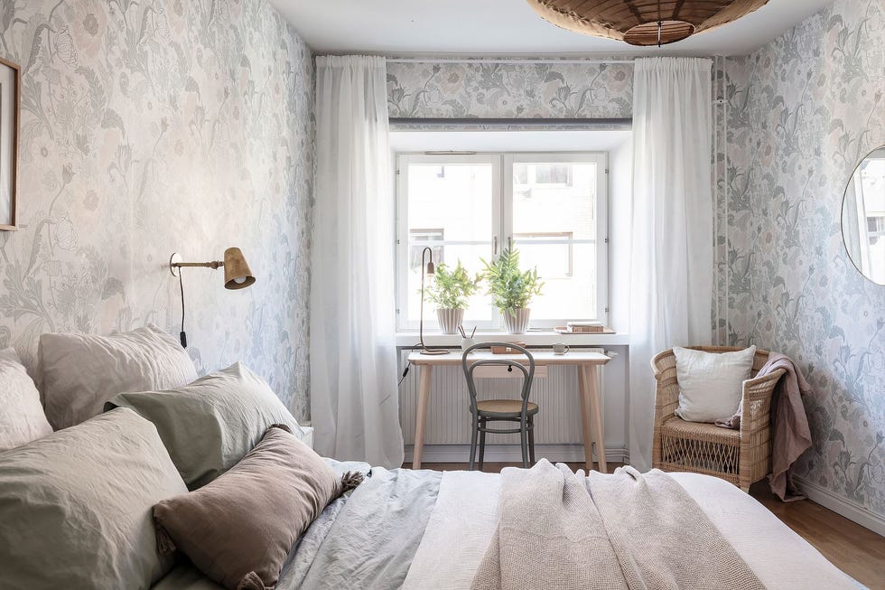 dormitorio de estilo nórdico y vintage con papel pintado floral con escritorio