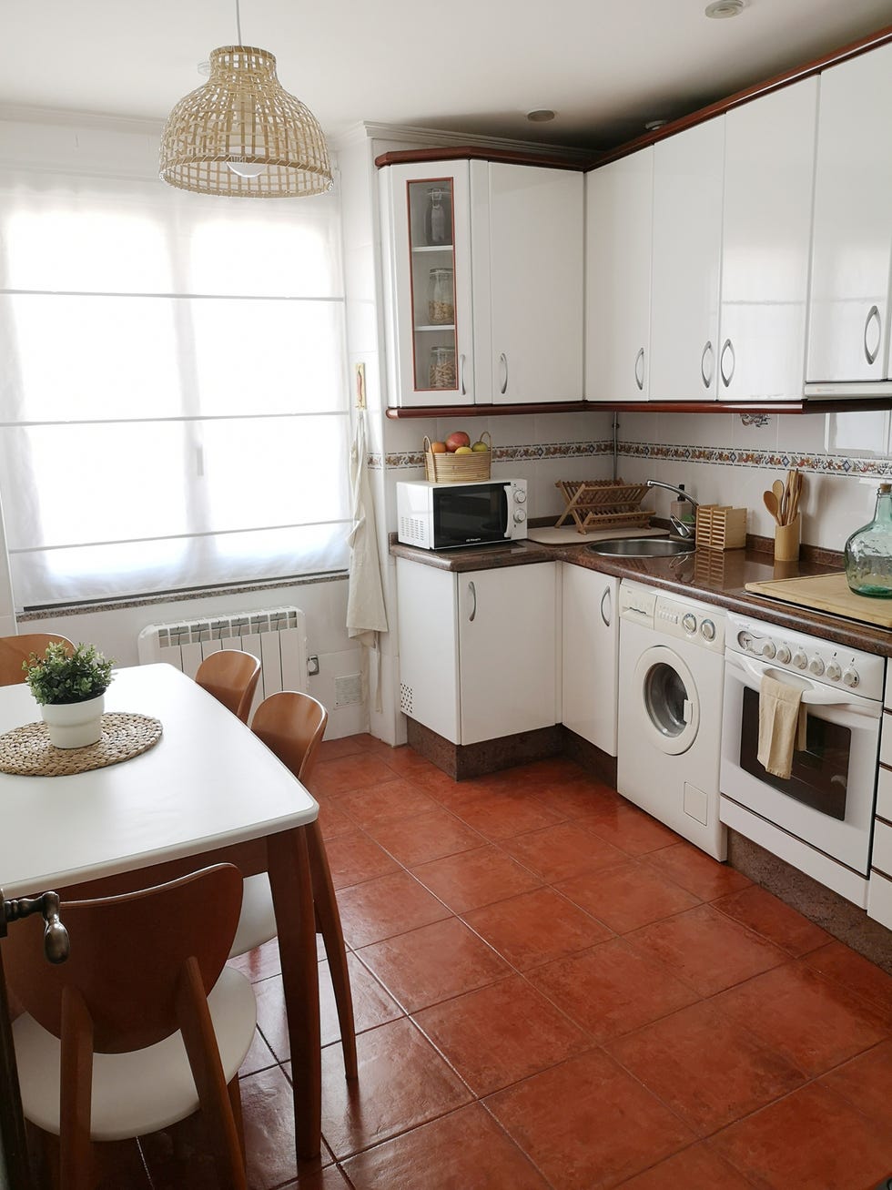 cocina blanca con lámpara de techo de fibras y estor