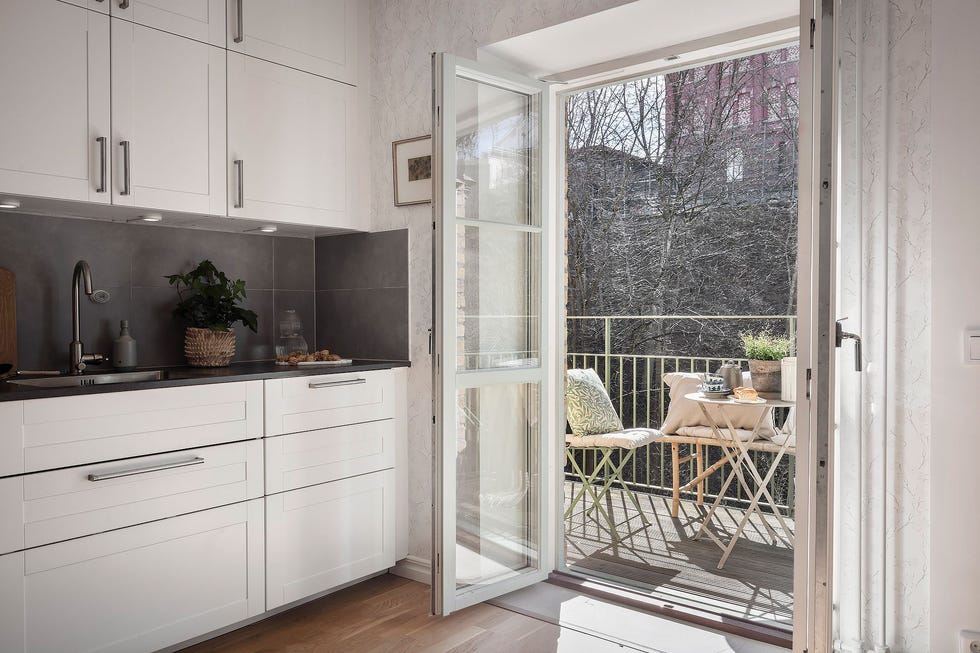 cocina blanca de diseño nórdico abierta a la terraza