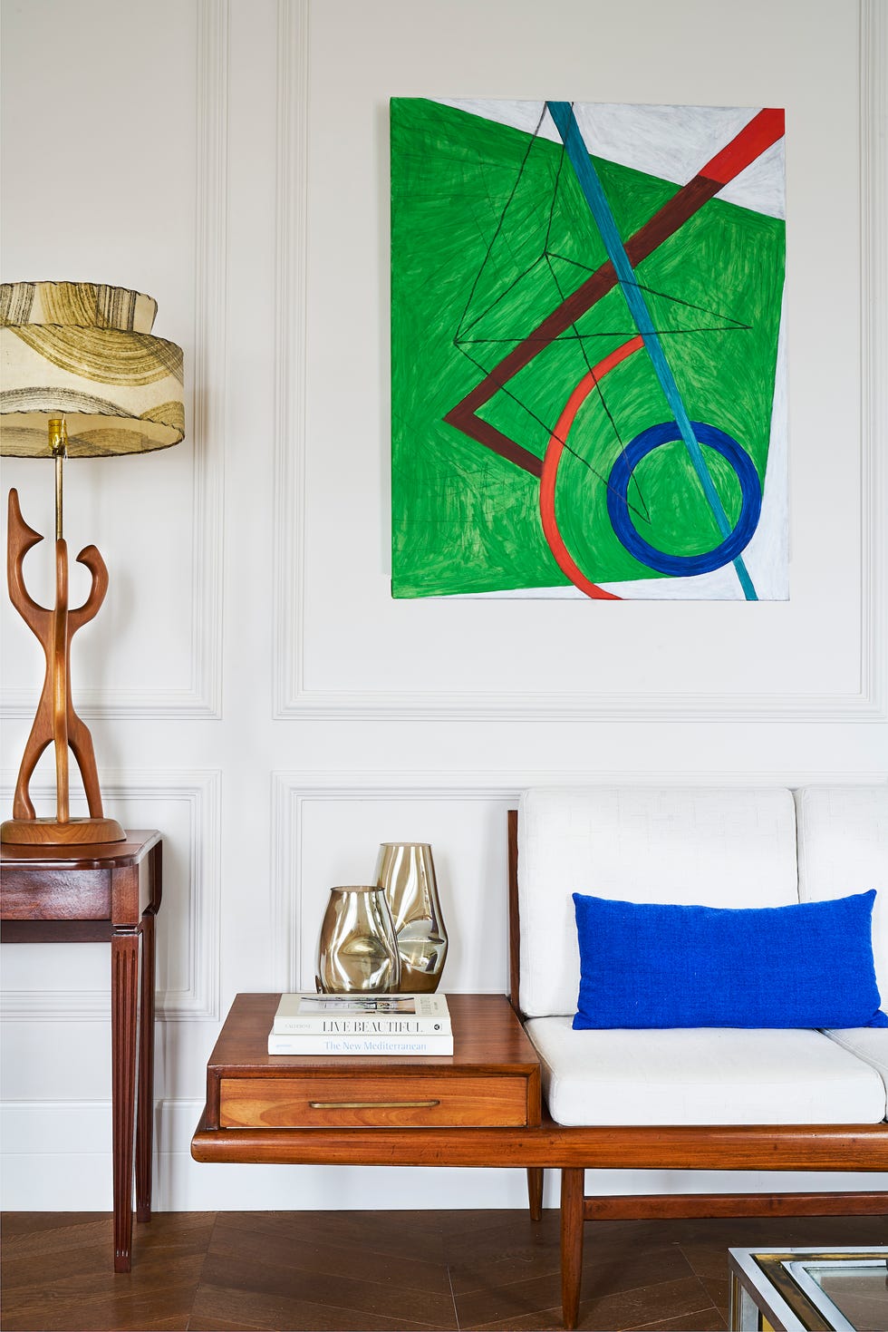 sofá de diseño con estructura de madera y cuadro de estilo moderno