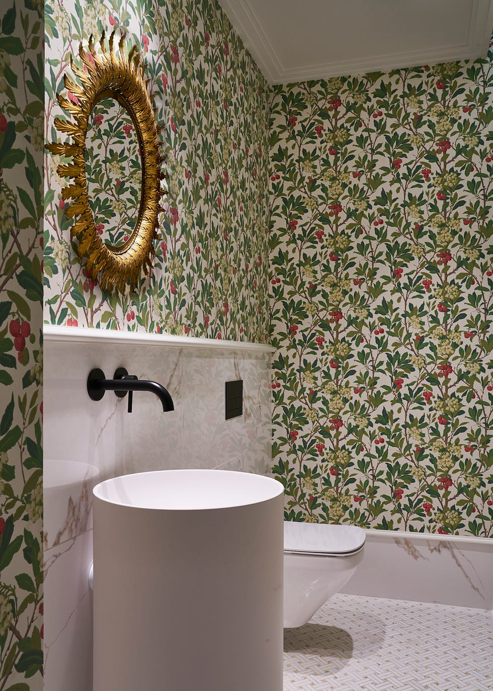 baño decorado con papel pintado vegetal y lavabo cilíndrico
