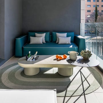 Terraza con sofá azul y mesa de centro de hormigón terraza con sofá azul y mesa de centro de hormigón
