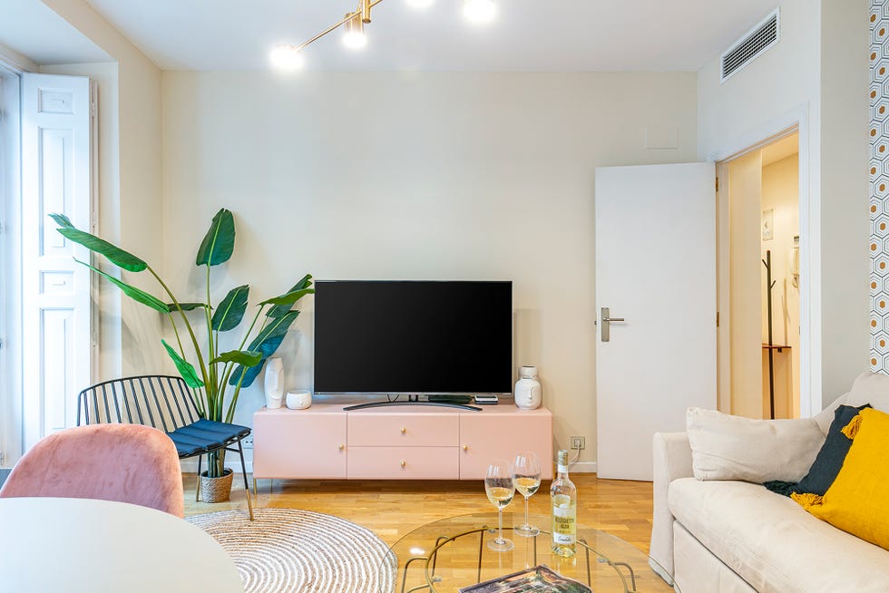 salón moderno con mueble de televisión en color rosa