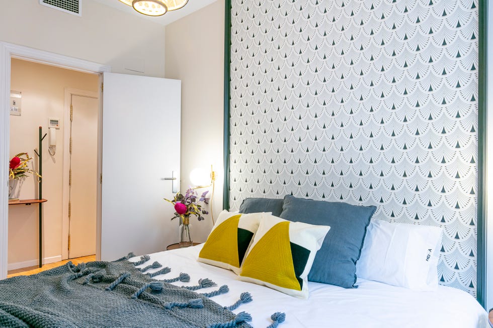 dormitorio con papel pintado geométrico en la pared del cabecero