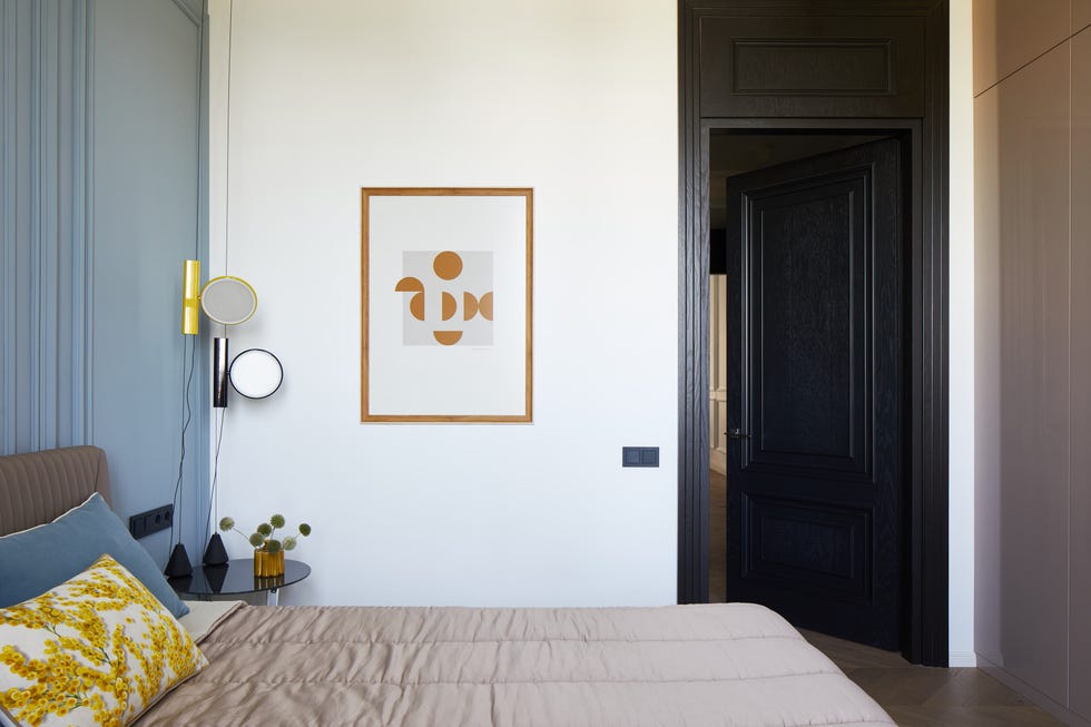 cabecero acolchado marrón y pared con molduras decorativas
