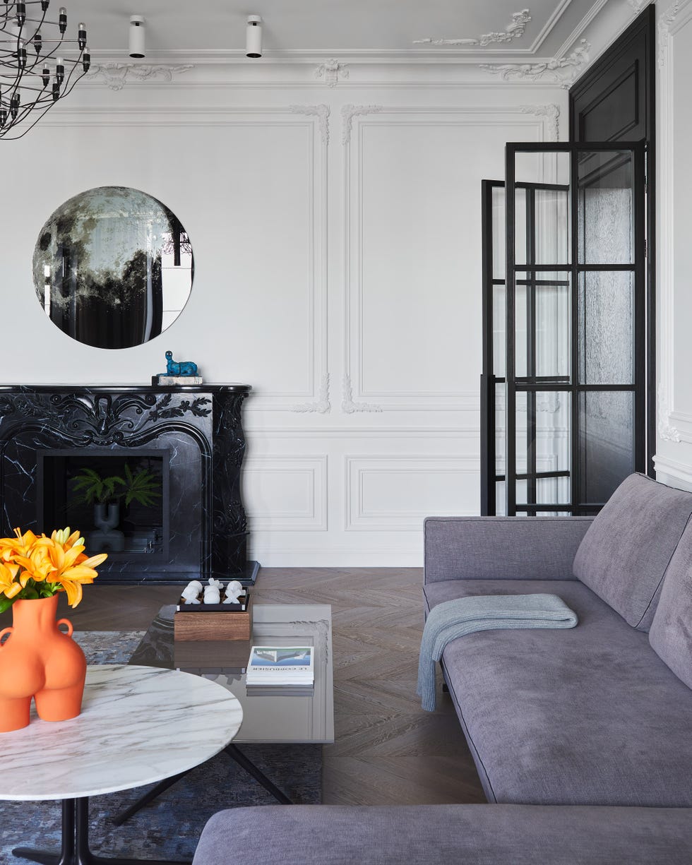 salón con molduras decorativas y chimenea de mármol negro