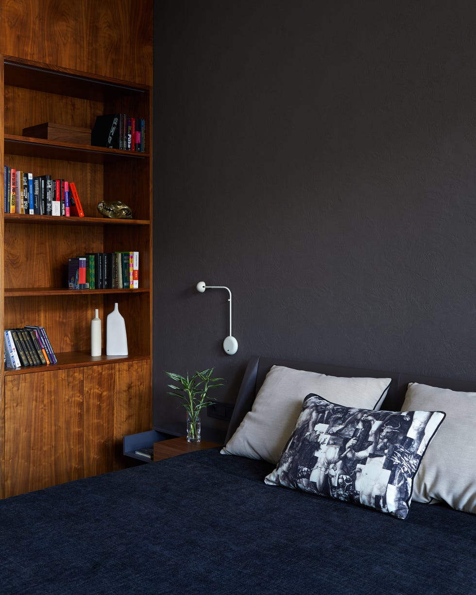habitación masculina en tonos oscuros con estantería de madera