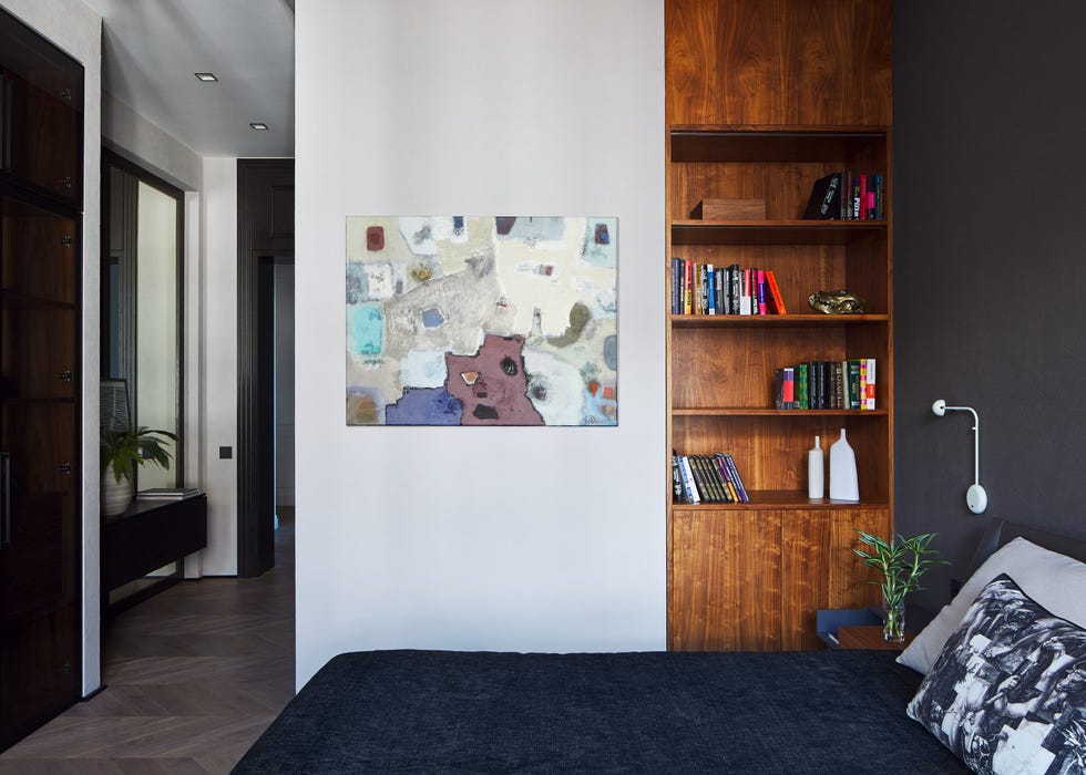 habitación masculina en tonos oscuros con estantería de madera