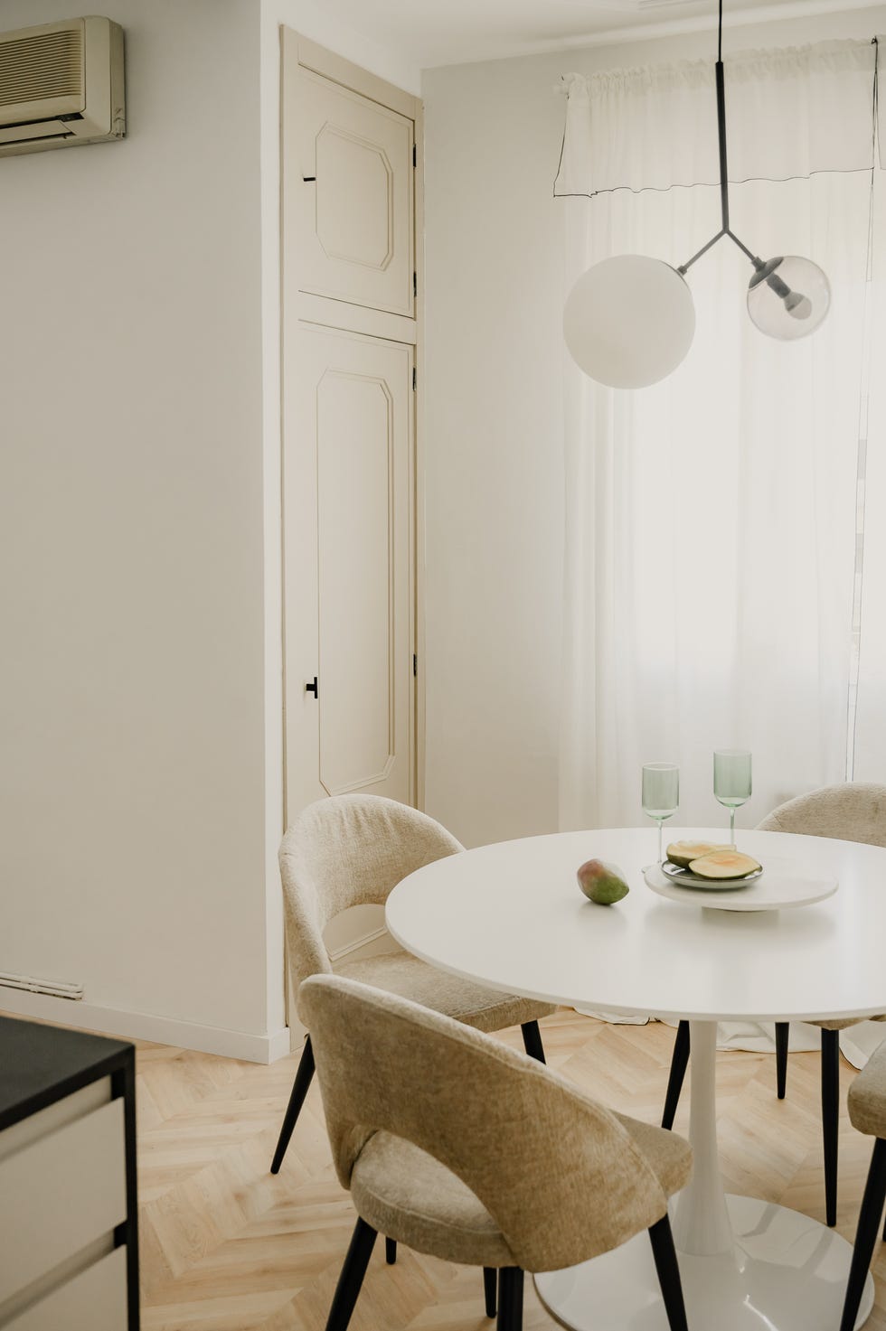 mesa de comedor redonda blanca y sillas tapizadas en beige