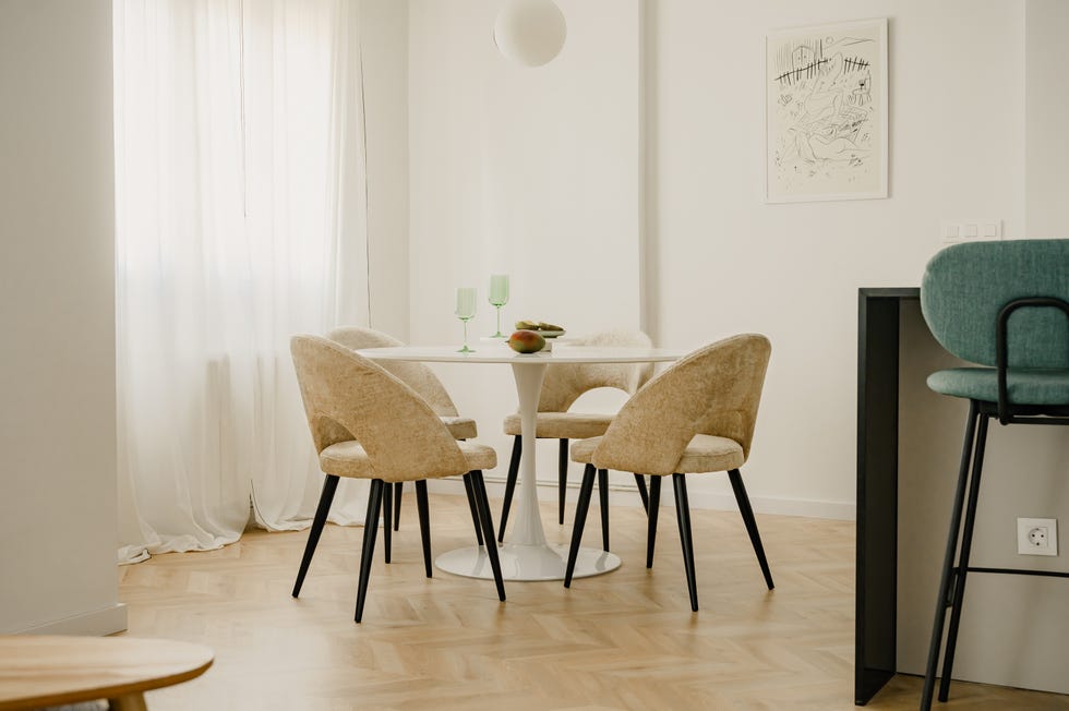 mesa de comedor redonda blanca y sillas tapizadas en beige