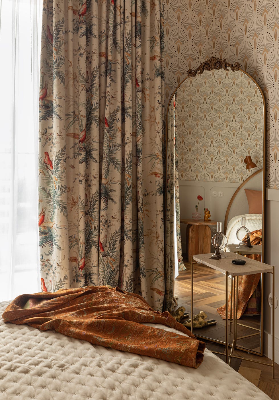 dormitorio con papel pintado con motivos art déco y espejo de pie