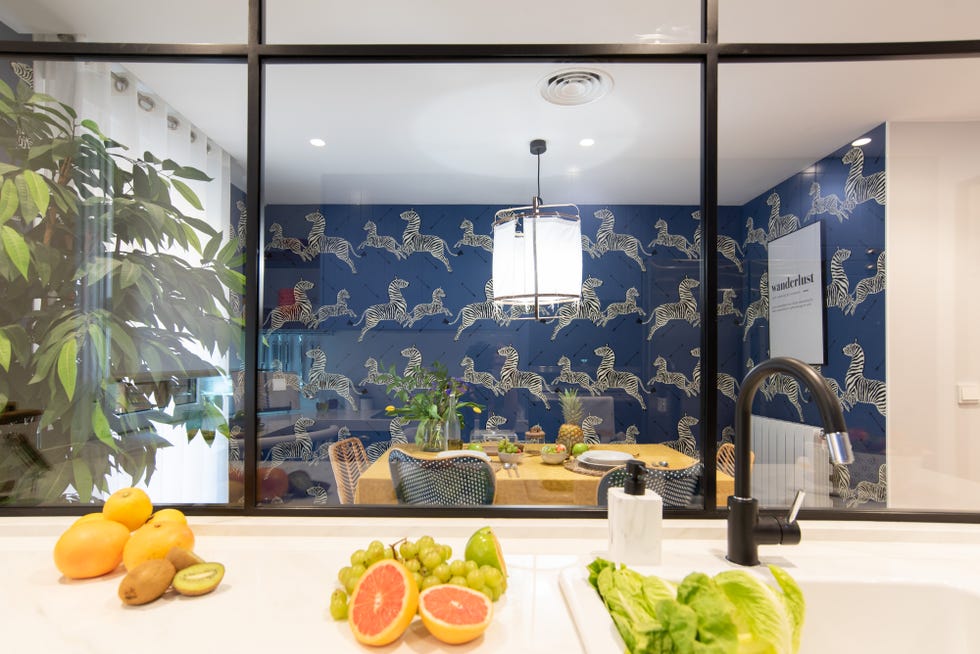 cocina con cerramiento de hierro y vidrio y comedor con papel pintado de cebras