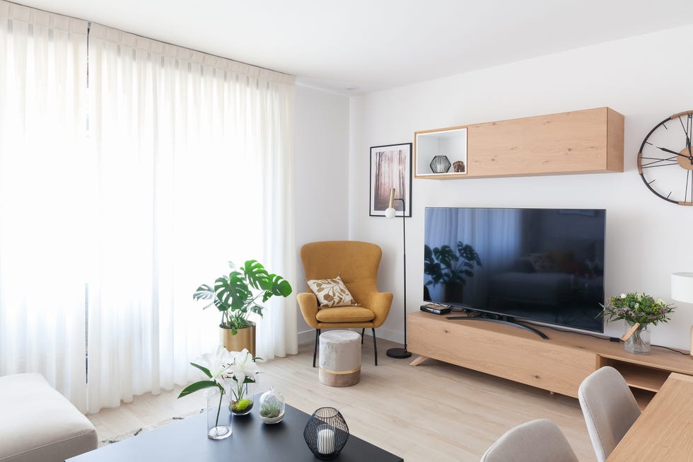 salón con butaca en color mostaza y mueble de tv nórdico de madera