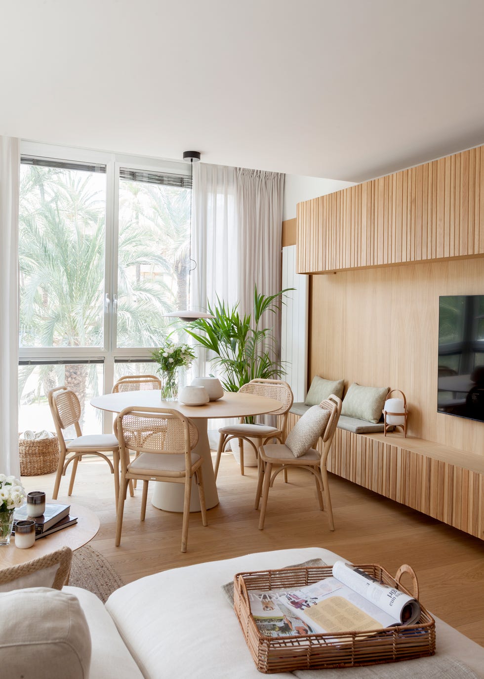 mesa de comedor redonda con sillas de madera y rejilla