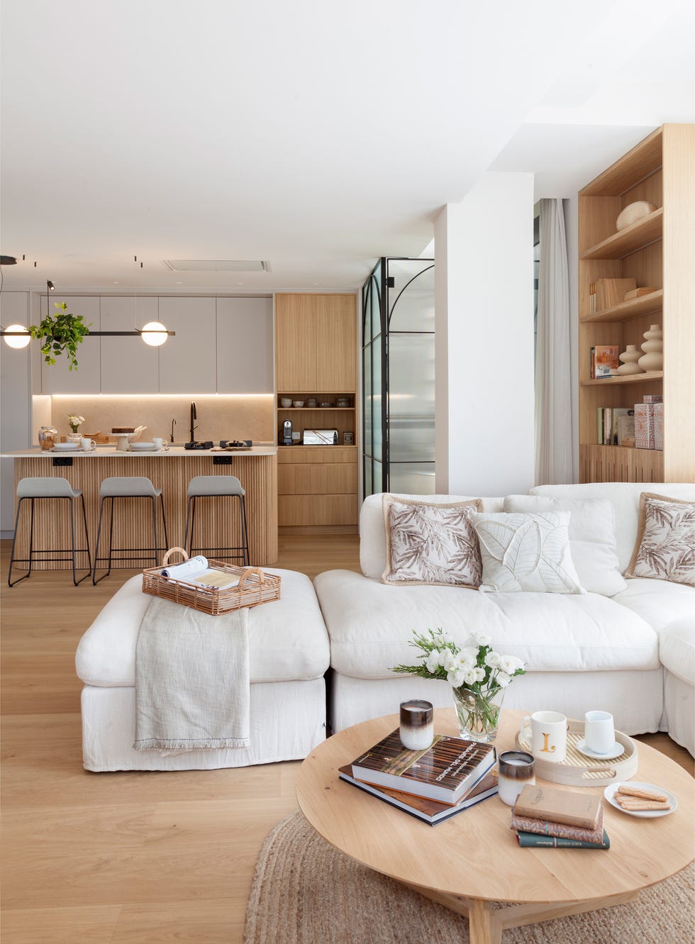 sofá rinconera blanco y mesa de centro redonda de madera