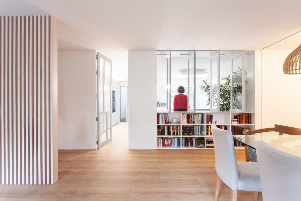 salóncomedor con biblioteca diseñado en blanco con estilo moderno