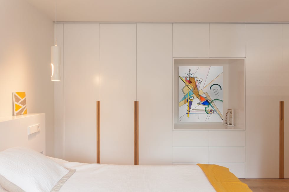 dormitorio moderno decorado en blanco con armario de obra y una hornacina