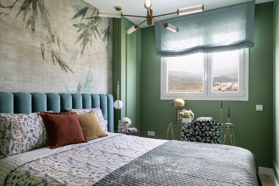 dormitorio con cabecero de terciopelo verde y mural botánico
