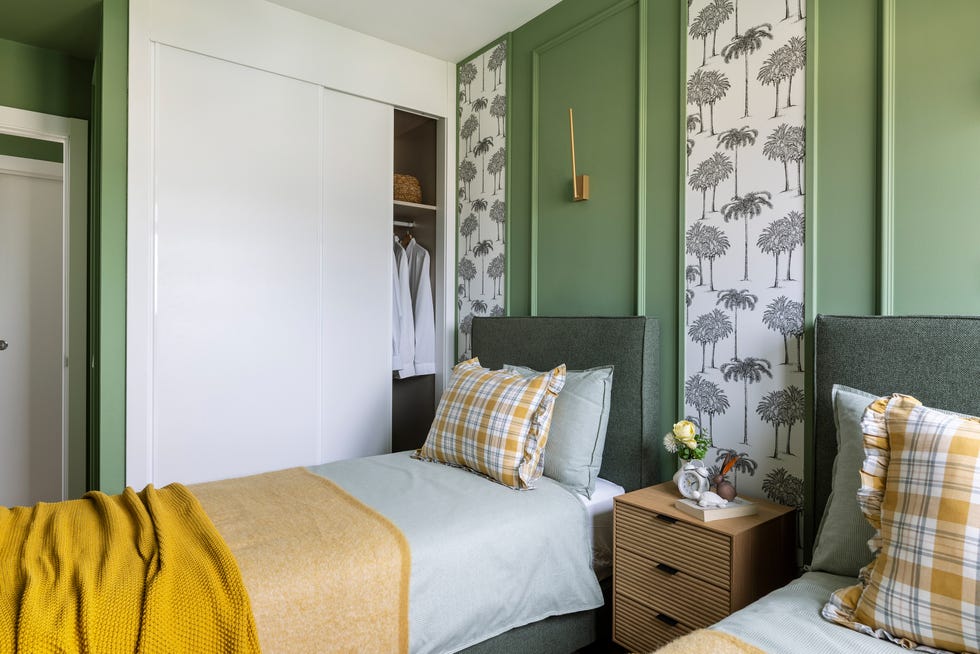 dormitorio con dos camas, paredes en verde y papel pintado con dibujos de palmeras