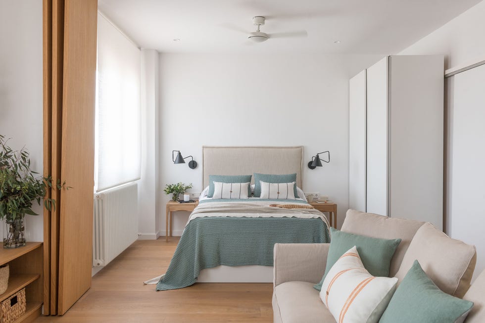 dormitorio con cabecero de tela natural y sala de estar con sofá